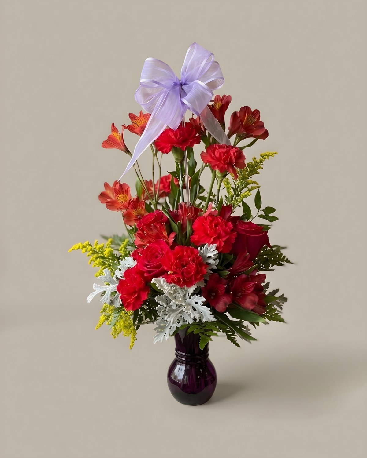Bright red, orange and yellow arrangement in a stone urn