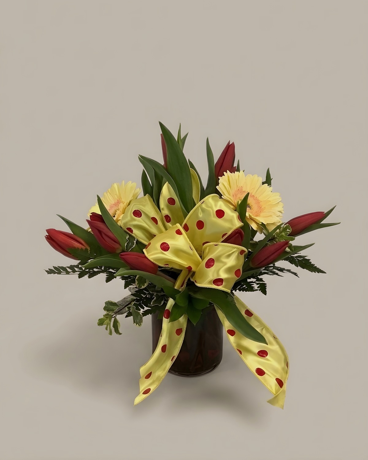Red ginger and yellow carnations with a yellow polka dot bow