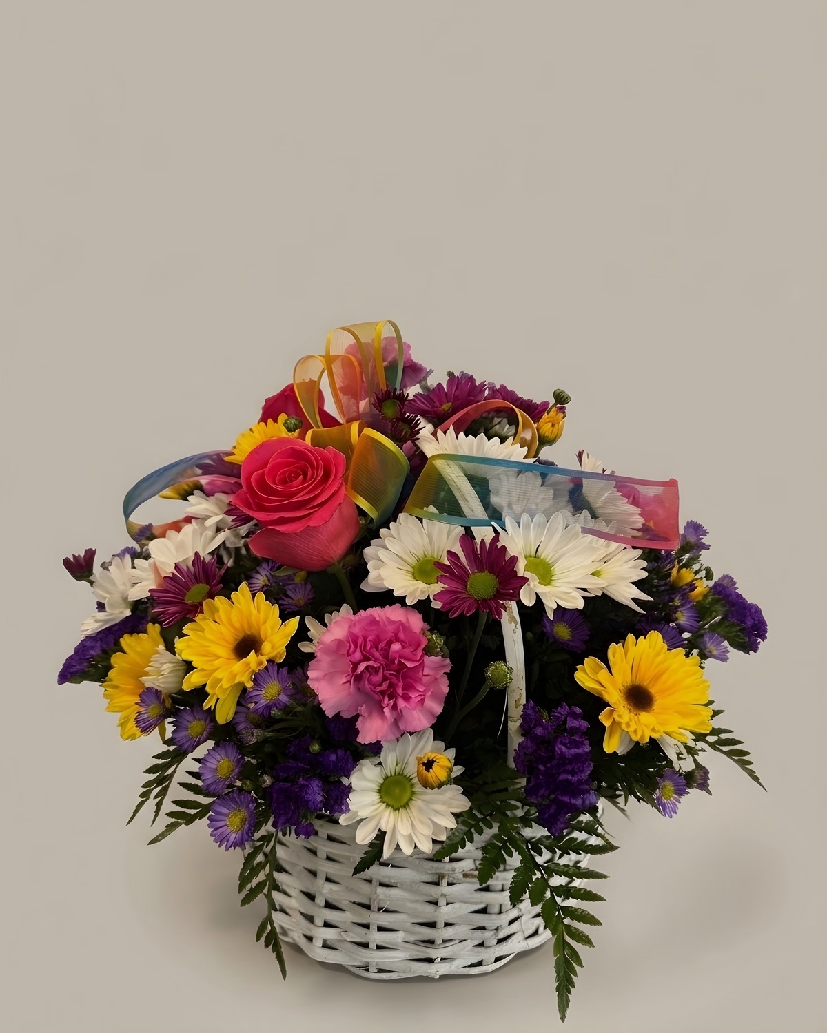 Yellow daisies, purple asters and mixed blooms in a white basket