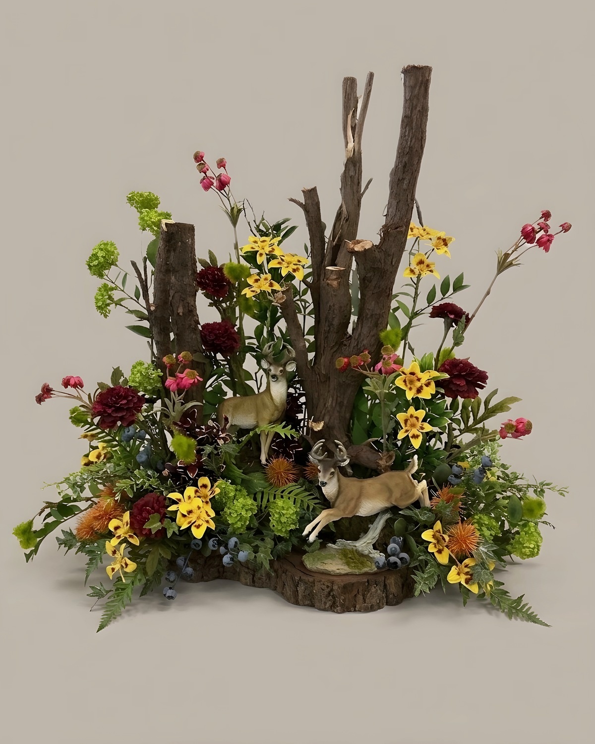 Silk woodland arrangement with birch posts and two deer figures on a wood base